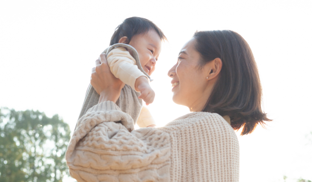 赤ちゃんを抱き上げる女性